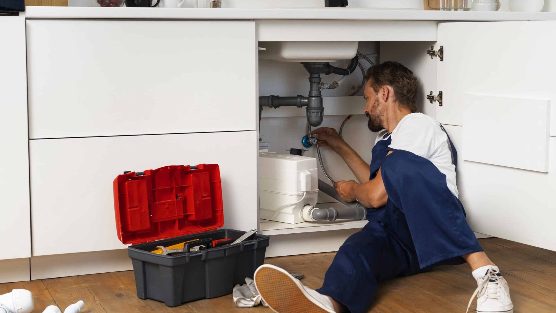 Plumber working under sink