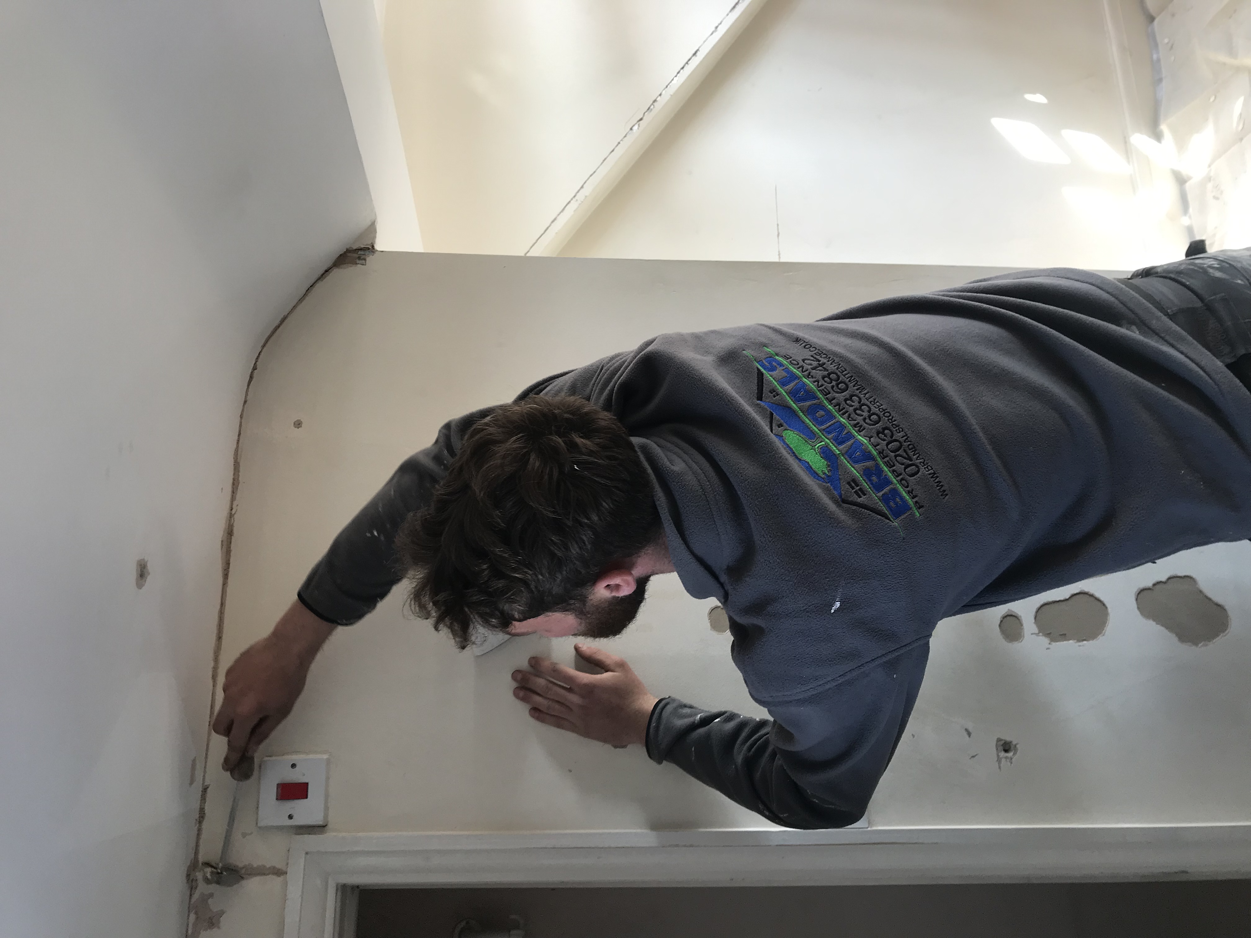 Brandals team member making good a wall during a renovation