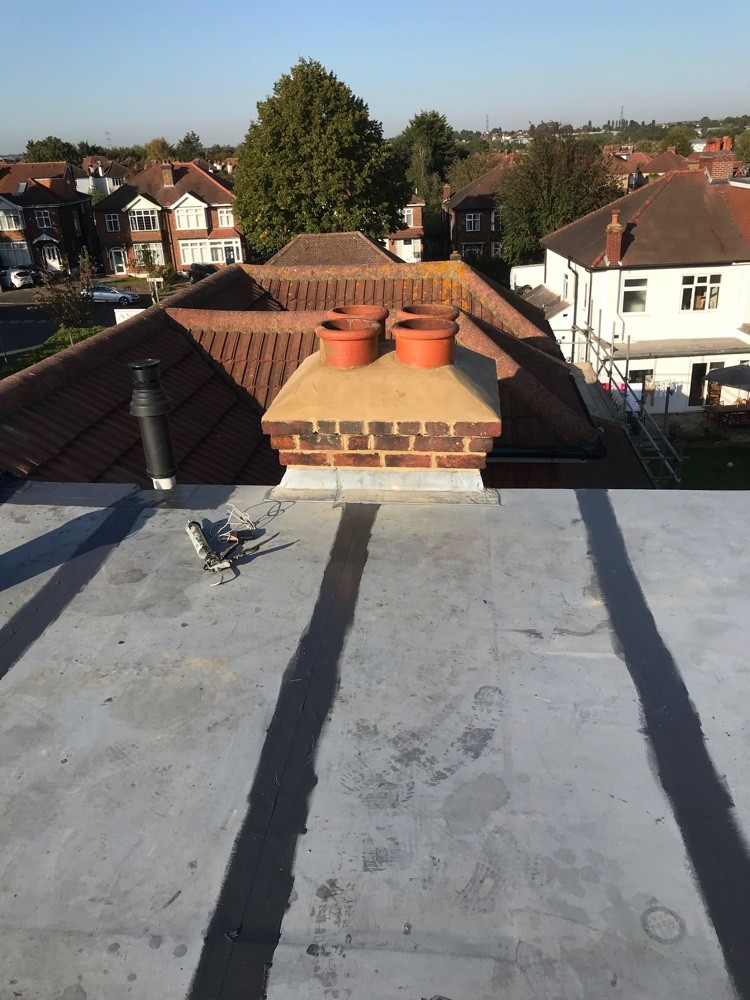 Newly repaired flat roof and repointed chimney stack