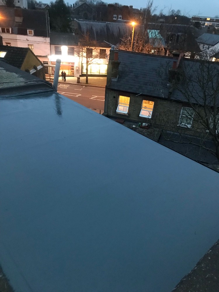 Completed grey flat roof at dusk on a London property