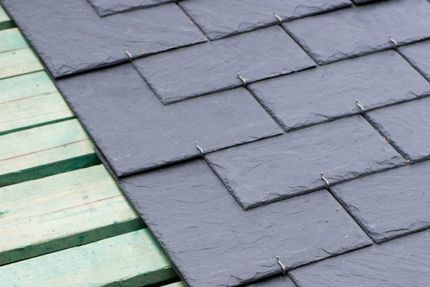 Natural slate roof tiles being laid on new timber battens